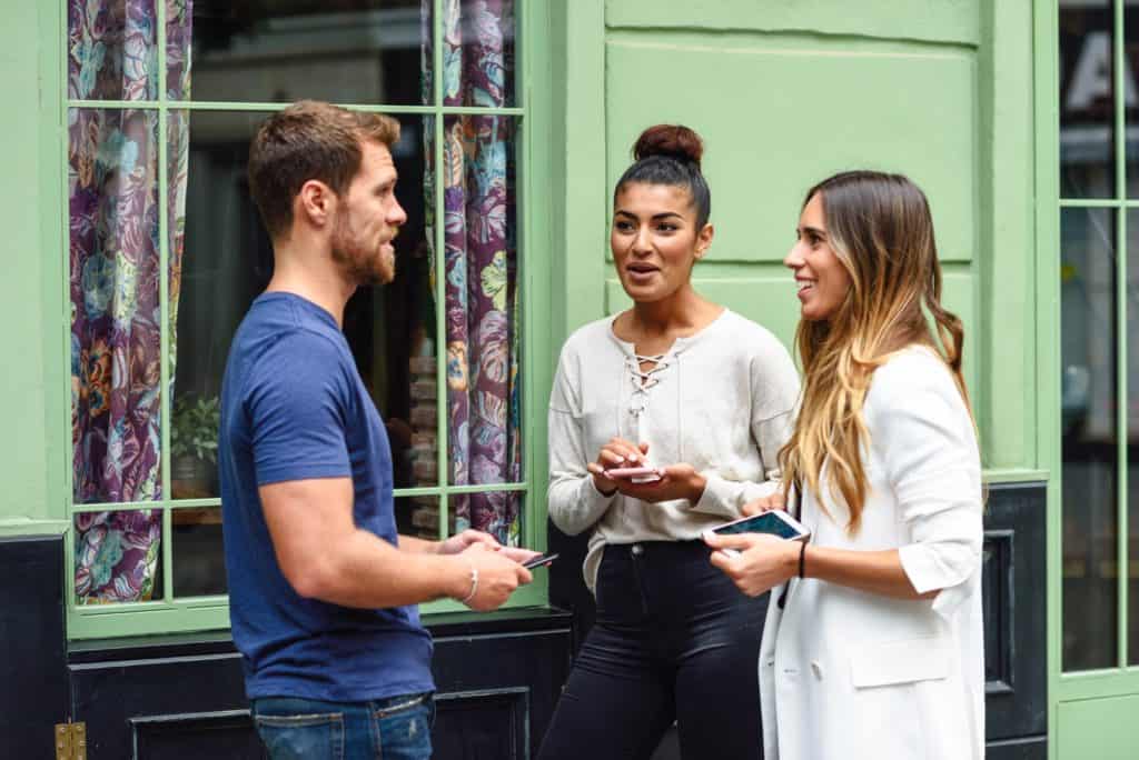Three multiethnic people friends talking and smiling outdoors