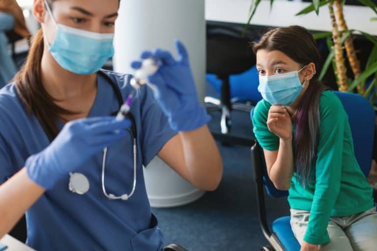 Scared Kid Looking At Nurse Physician With Syringe