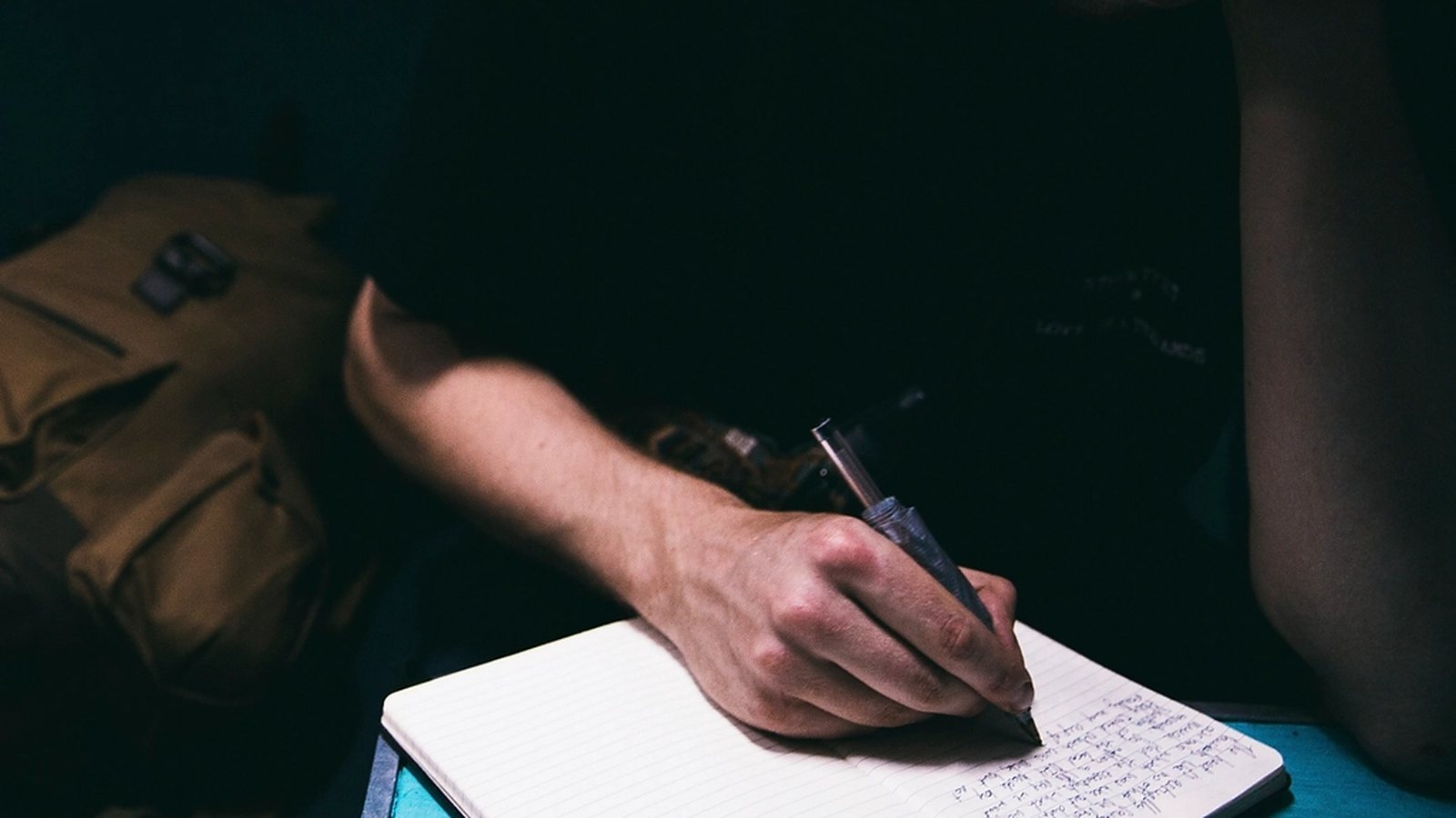 Journalist writing notes by hand in a notebook