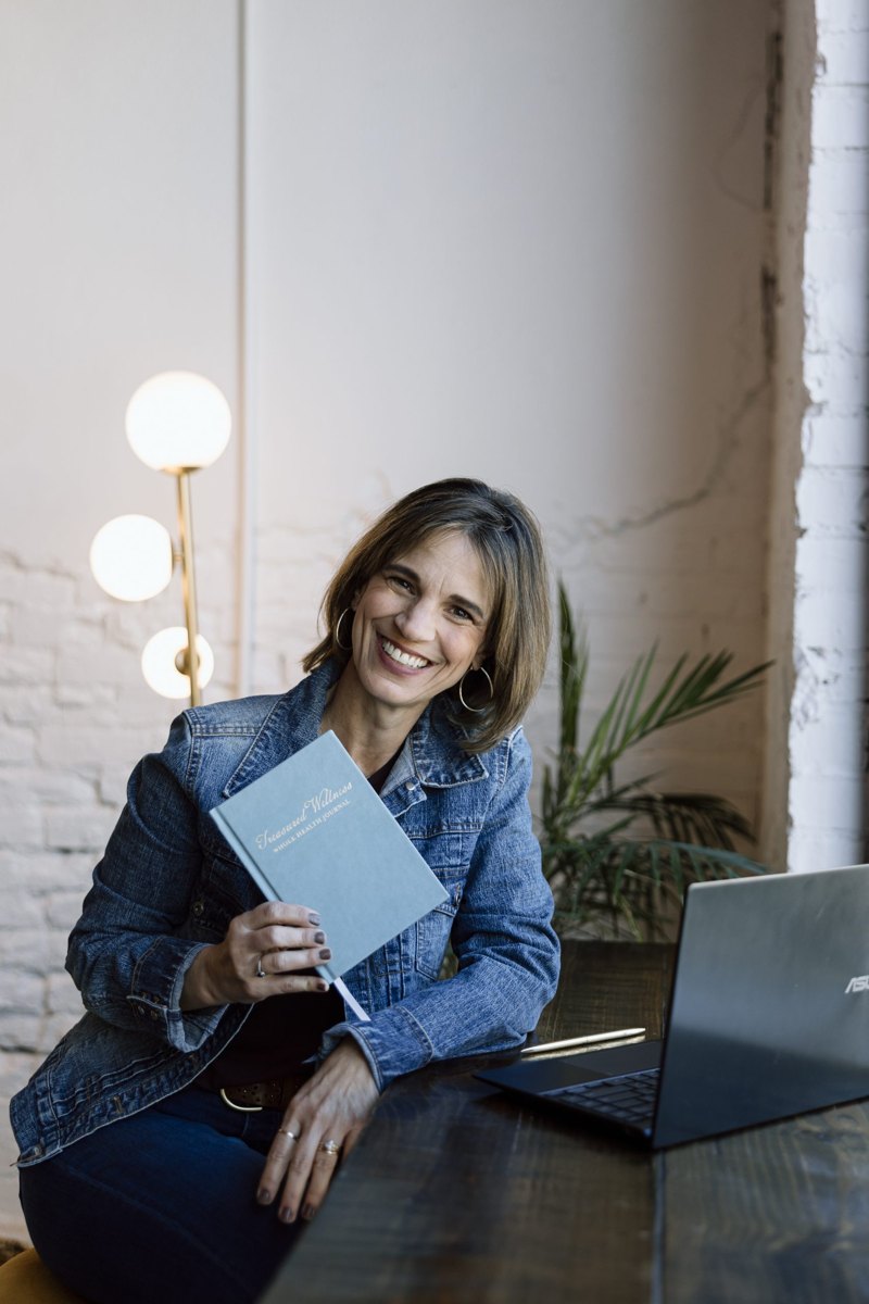 Michelle McCoy holding the Treasured Wellness Journal